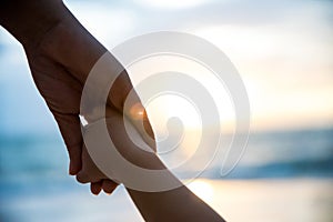 Soft focus parent hold the little child hand during sunset photo
