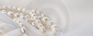 The soft focus on the pearls exudes a gentle, soothing aura on a pristine white fabric. It subtly champions the cause of