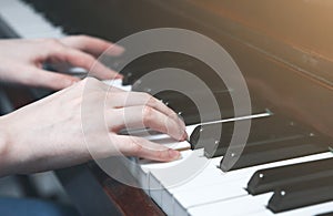 Soft focus photo. Woman is playing piano. Hands on the keyboard. Beautiful music. Creative girl at the musical instrument.