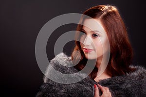 Soft focus portrait of beautiful young woman wearing a fur coat..