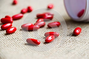 Soft focus of red tablets with white medicine box