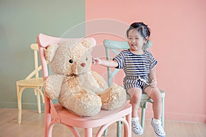 Soft Focus of a Two Years Old Child Sitting with her Teddy Bear. photo