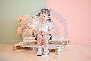 Soft Focus of a Two Years Old Child Sitting with her Teddy Bear. photo
