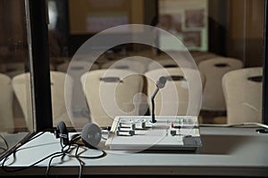 Soft focus of wireless Conference microphones and notebook in a meeting room. translators cubicle . interpreting - Microphone and