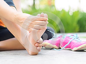 Soft focus woman massaging her painful foot while exercising. photo