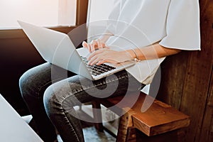 Soft focus of woman working with laptop in coffee shop. Vintage tone.