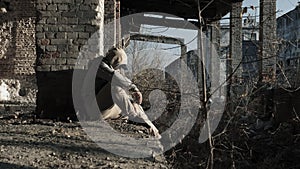 Soft focus A young man in a ruined house, a lonely and sad guy sits in a ruined house. The young guy has social problems