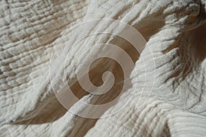 Soft folds on thin white cotton muslin fabric