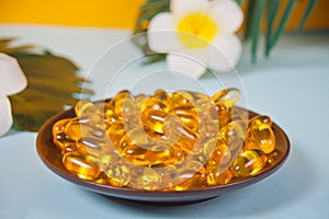 Soft gelatin capsules. Natural vitamins supplement. Vitamin A, E, fish oil, primrose oil. Tropical background
