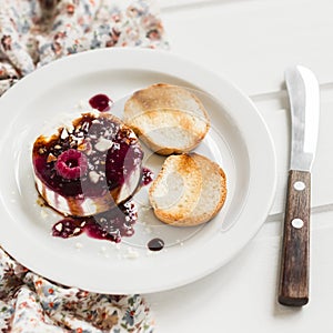 Soft goat cheese with berry sauce, balsamic vinegar and nuts - a delicious appetizer with wine