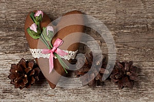 Soft heart made of cloth with pink roses on a wooden background