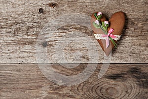 Soft heart made of cloth with pink roses on a wooden background