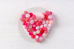 Soft heart made of small wool pompons as a sign of gentle love