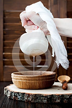 Soft homemade fresh ricotta cottage cheese made from milk, draining on muslin cloth. photo