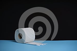 Soft hygienic white toilet paper, on black blue background