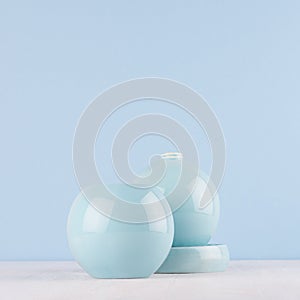 Soft light blue pastel color in home decoration - sphere ceramic vases on white wood board.