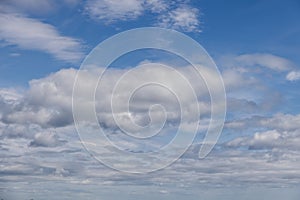 Soft light highlights voluminous clouds over calm blue backdrop