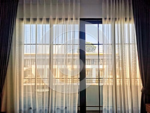 Soft lights shining through transparent curtain from window in bedroom.