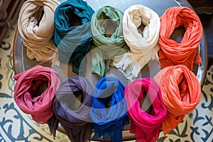 soft, lightweight scarves arranged by color on a circular display