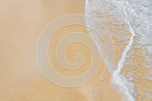 Soft ocean wave foam on clean sandy beach