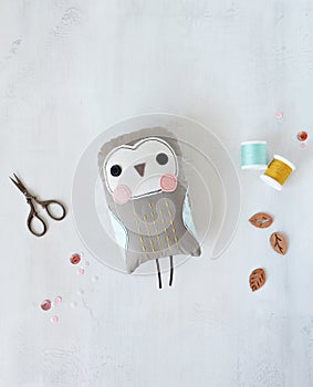 Soft owl toy, embroidery scissors, sequins, spool threads and decorative wooden leaves