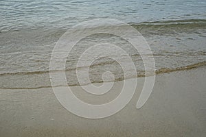 Soft pastel clean sandy beach with fresh clear sea water and light bubble wave line background and copyspace on Ornos shore