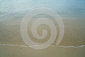 Soft pastel clean sandy beach with fresh clear sea water and white foamy wave line background and copyspace on Ornos shore