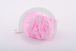 Soft pink bath puff or sponge on white background