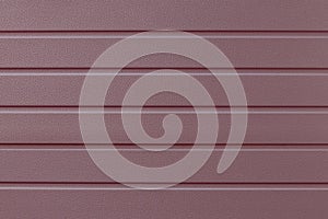 Soft pink striped steel surface. Strip pattern on the metal door. Reflecting metallic cladding of wall, texture. Ribbed rose-color
