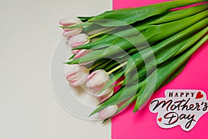 Soft Pink tulips and greeting card with text Happy Mothers Day.tulips and a sign for mother`s day. Beautiful bouquet of