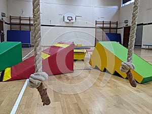 Soft play equipment spread out across the gym floor empty