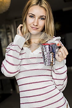 Soft portrait of teenage girl drinking hot coffee at home,