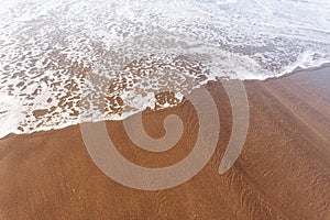 Soft sea Wave On Sandy Beach. Summer and vacations and travel concept. Selective focus, with copy space.