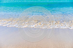 Soft sea waves at sand beach shoreline with clear blue sea water