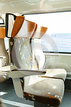 Soft seats in a comfortable train car. The route along the coast, outside the window a beautiful seascape. Bright sunny day.