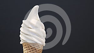 Soft serve ice cream cone on black background. close up
