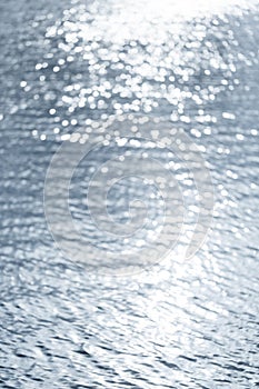 Soft and smooth water wave ripple with blurred bright abstract bokeh of sun light.