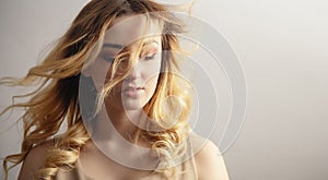 Soft studio portrait of a beautiful  woman, girl face with curly hair disheveled from wind , the concept of natural beauty,