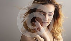 Soft studio portrait of a beautiful young woman, girl face with curly hair disheveled from wind , the concept of natural beauty,