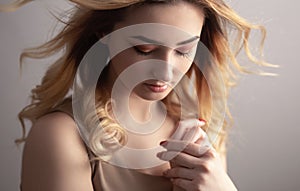 Soft studio portrait of a beautiful young woman, girl face with curly hair disheveled from wind , the concept of natural beauty,