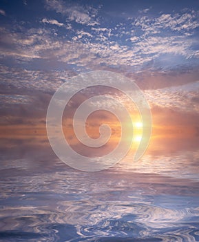 Soft sunset in the sky and cirrus clouds with bright sun over the sea with waves