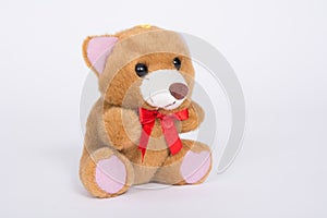 Soft toy bear with a red bow on a white background