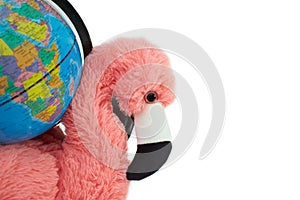 Soft toy pink flamingo with globe isolated on the white background.