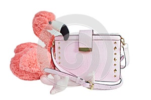 Soft toy pink flamingo with pink lady`s bag isolated on the white background.