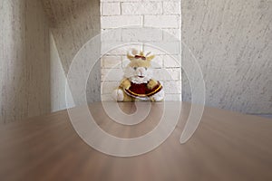 Soft toy on a table near a brick white pipe in a residential attic