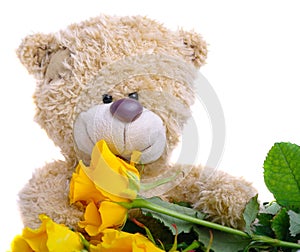 Soft toy teddy bear with a bouquet of yellow roses