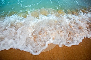 Soft Wave Of Blue Ocean selective focus on sandy beach.