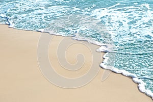 Soft wave and sea bubble of blue sea on sandy beach
