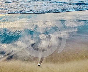 Soft wave of the sea sand and pebble close up at sunset