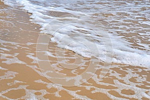 Soft wave of the sea on the sandy beach as background